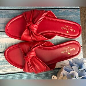 Kate Spade leather, flat, soft sandals in the color red with gold logo.